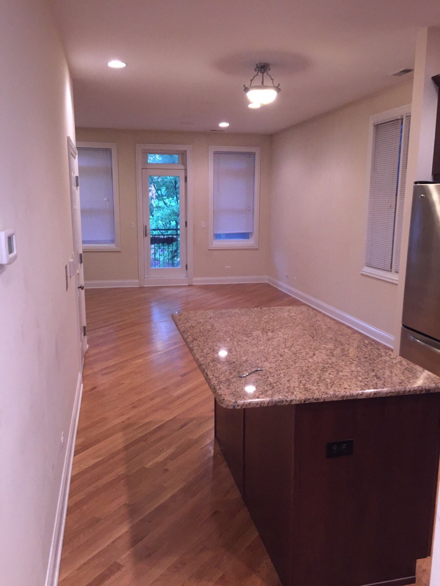 an empty kitchen with a granite counter top in the center