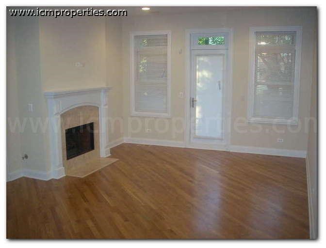 a living room with a fireplace and wooden floors