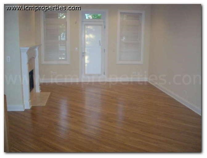 an empty living room with a wooden floor
