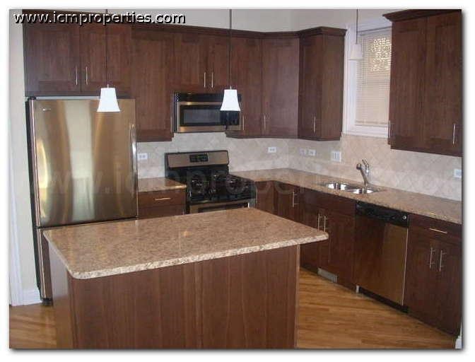 a kitchen with wooden cabinets and a stainless steel refrigerator