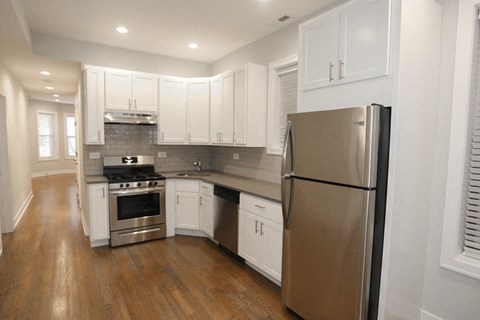 a kitchen with white cabinets and stainless steel appliances