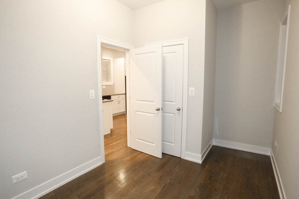 a bedroom with two doors and a door to a bathroom