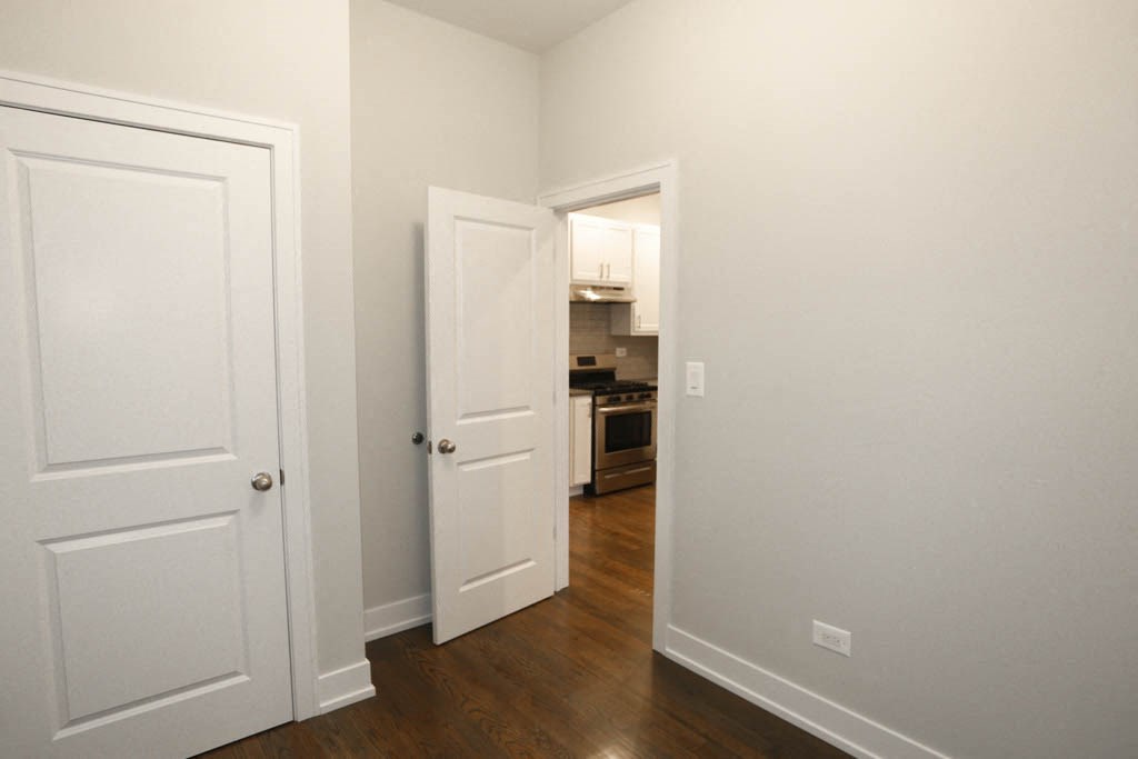 a bedroom with two closets and a door to a kitchen