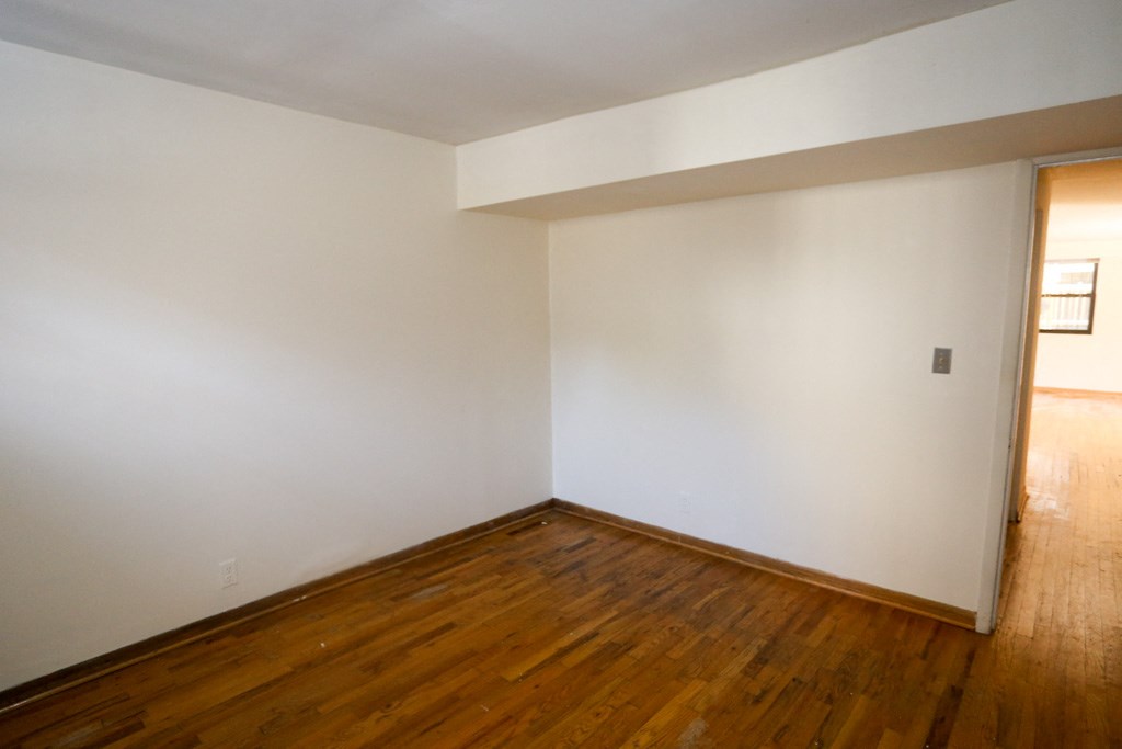 an empty living room with white walls and wooden floors