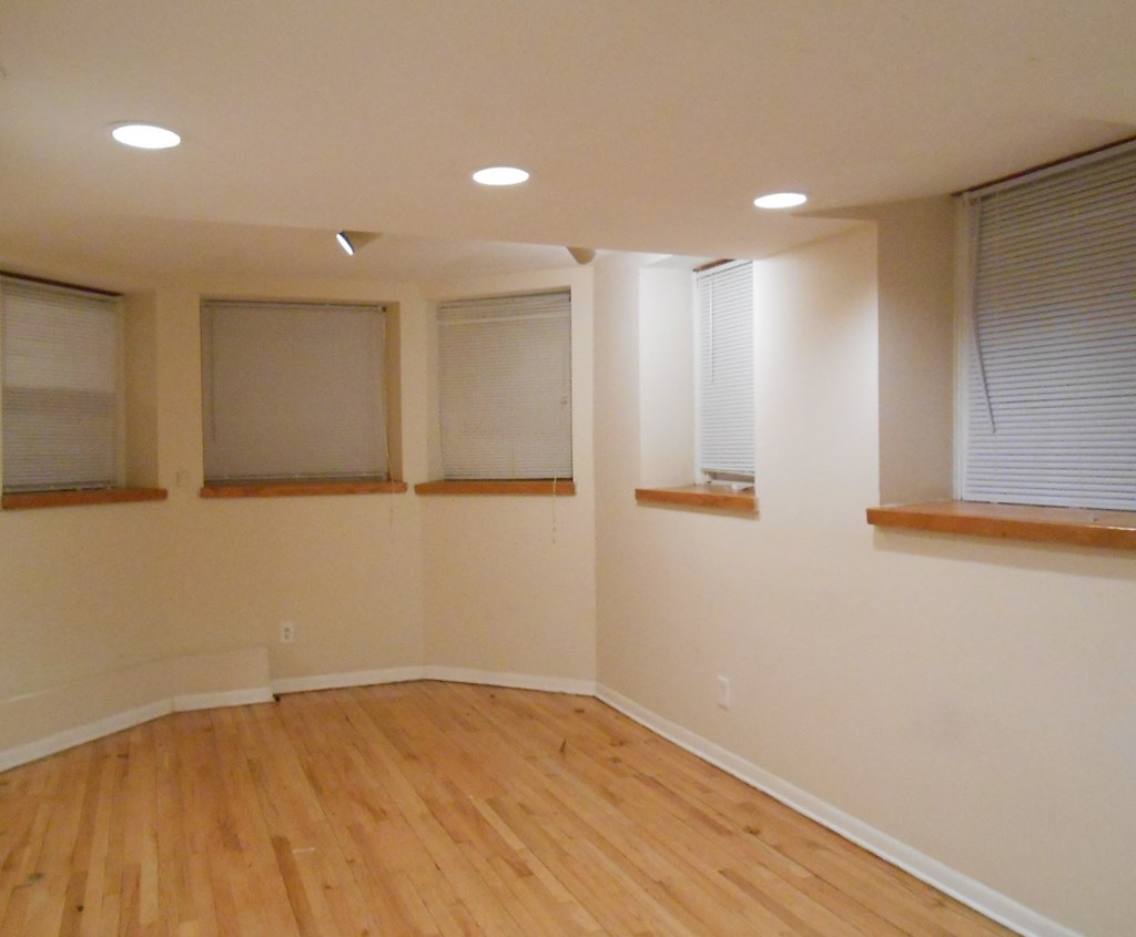 an empty living room with wood floors and windows