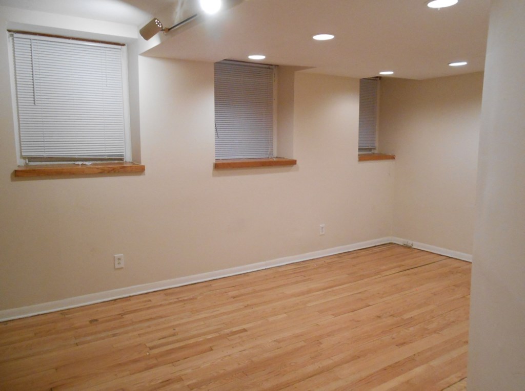 an empty living room with wood floors and windows