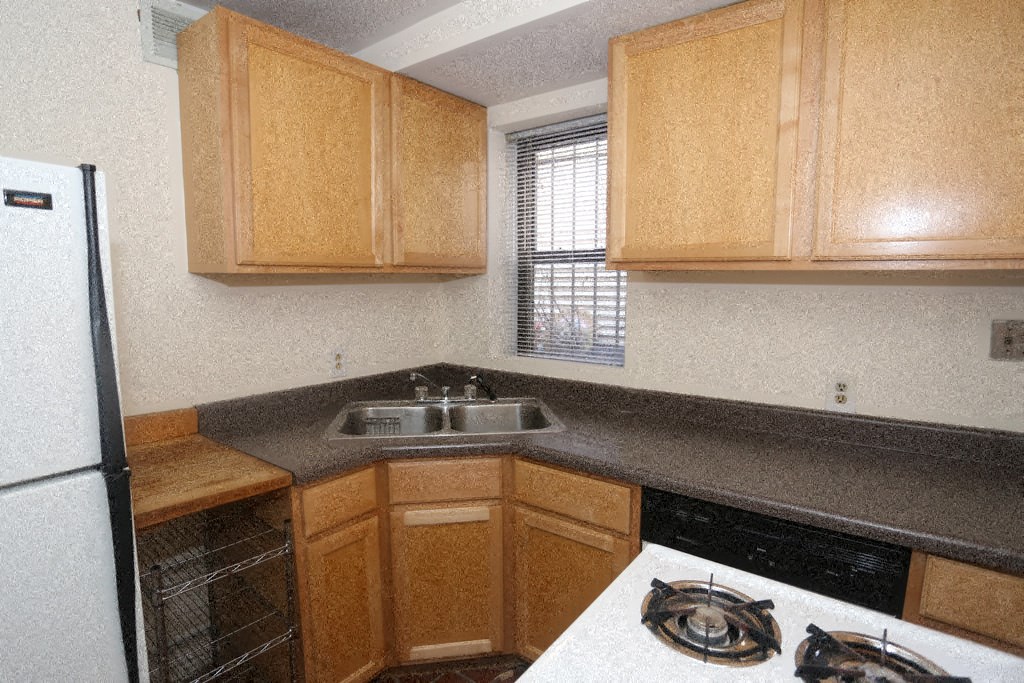 an empty kitchen with wooden cabinets and a sink