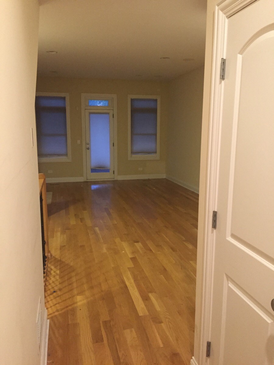 an empty living room with a hard wood floor