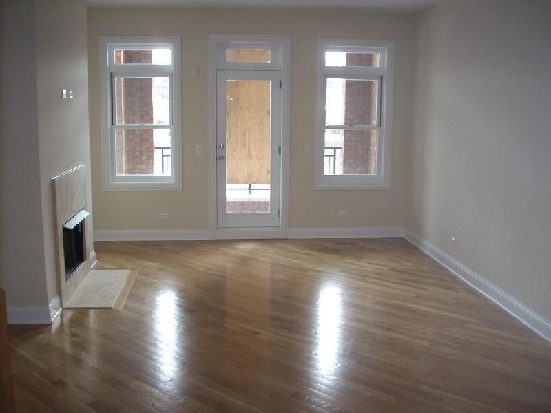 an empty living room with a fireplace and windows