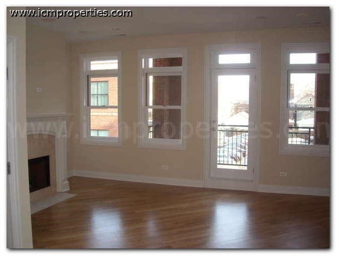 an empty living room with a fireplace and windows