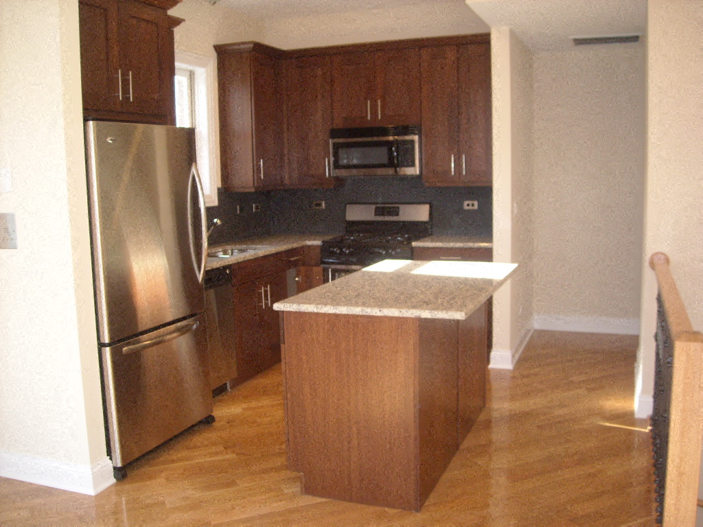 a kitchen with stainless steel appliances and wooden cabinets