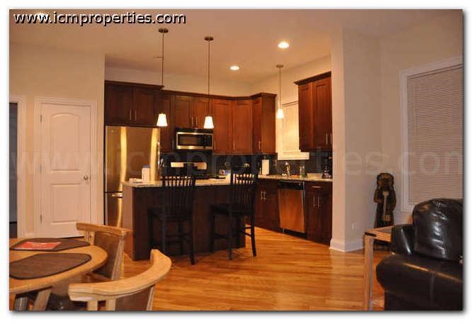 a kitchen and living room with a table and chairs