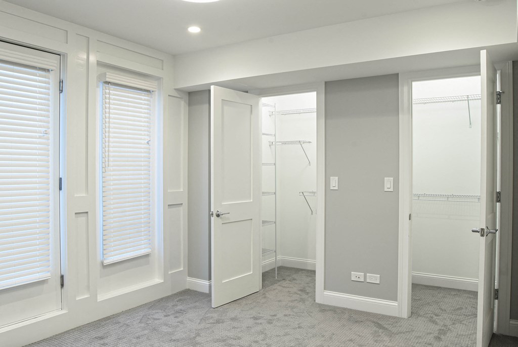 an empty room with white doors and windows