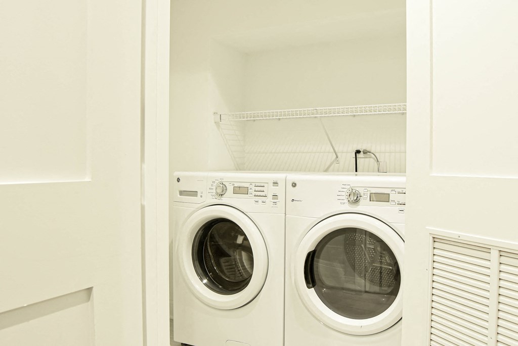a white washer and dryer in a white laundry room