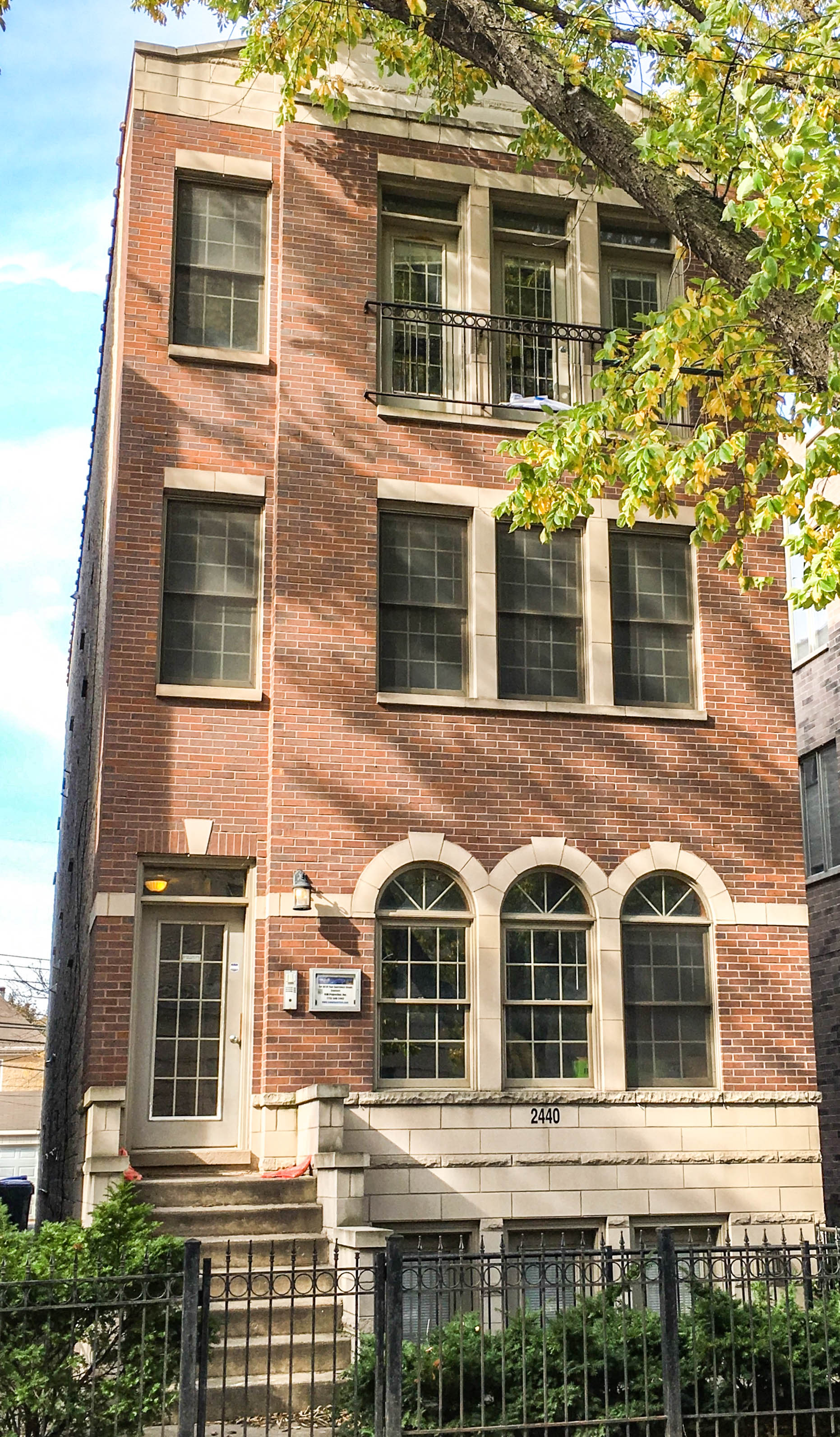 a tall brick building with windows and a fence