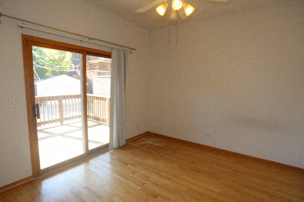 an empty living room with a sliding glass door to a deck