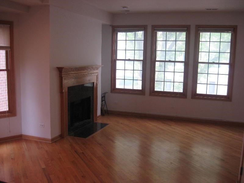 a living room with a fireplace and wooden floors