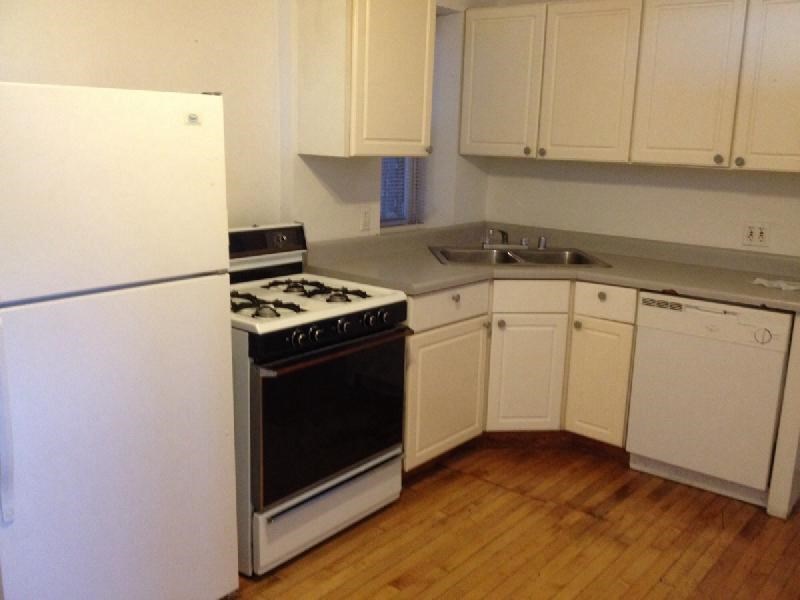 a kitchen with white cabinets and a stove and refrigerator