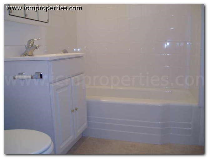 a bathroom with a toilet and a tub and a sink