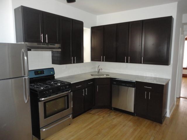 a kitchen with black cabinets and stainless steel appliances