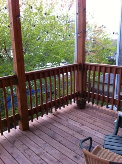 a porch with a wooden railing and a basket on it