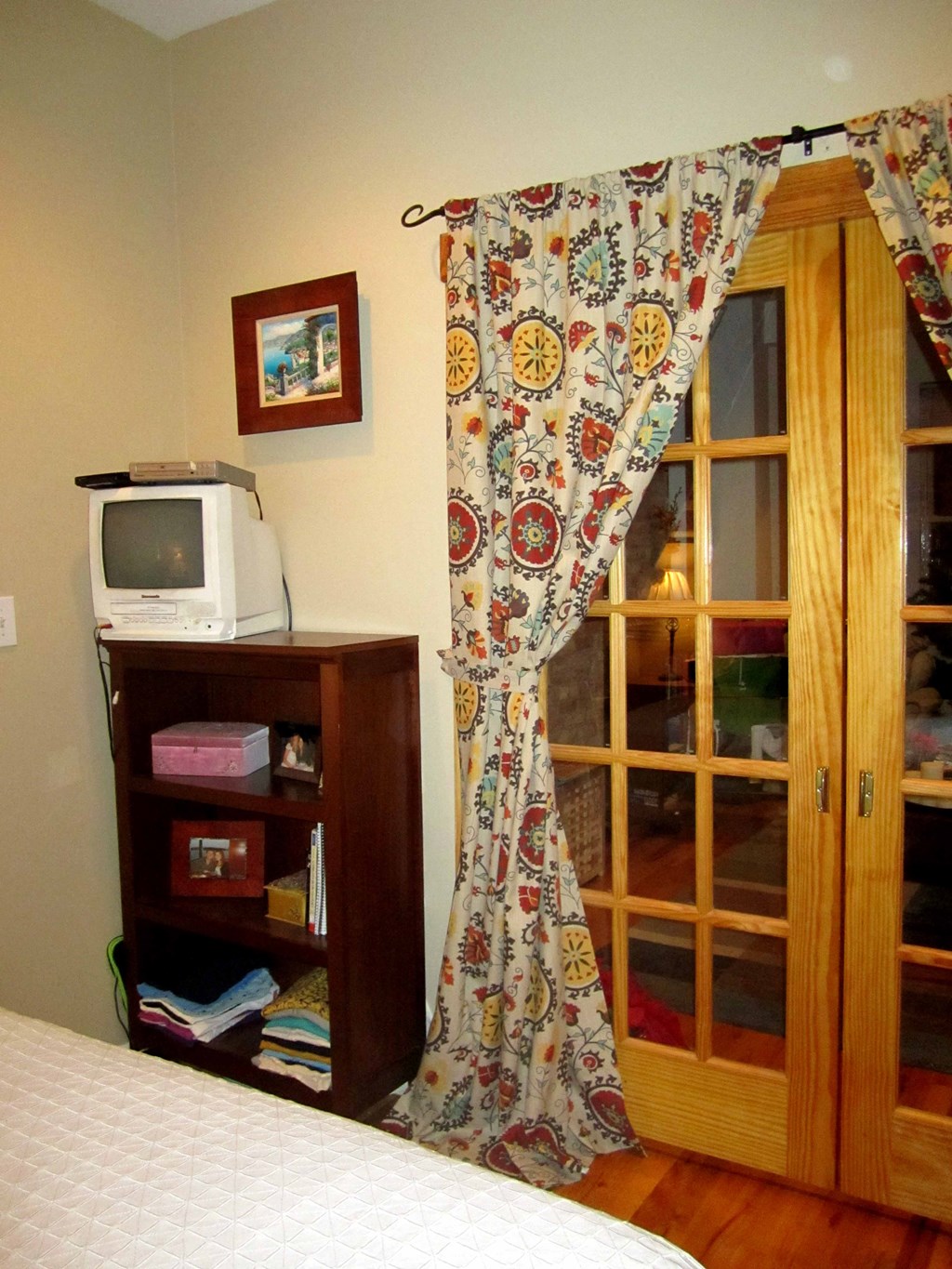 a bedroom with a bed and a window with a curtain