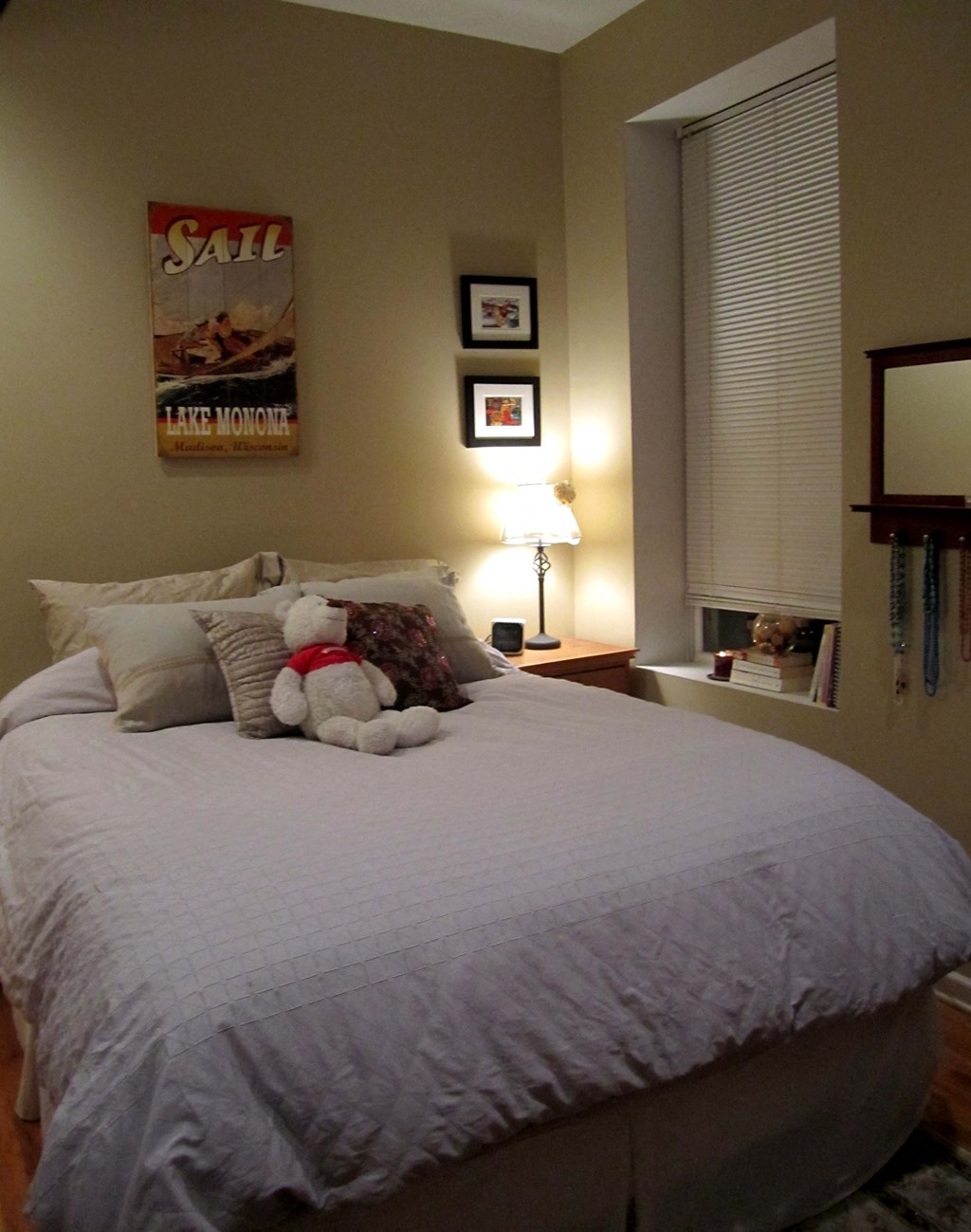 the bedroom has a large bed with a teddy bear on it
