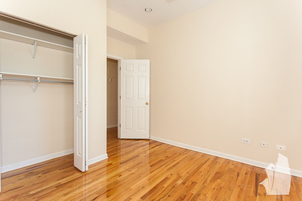 an empty room with wood floors and a closet