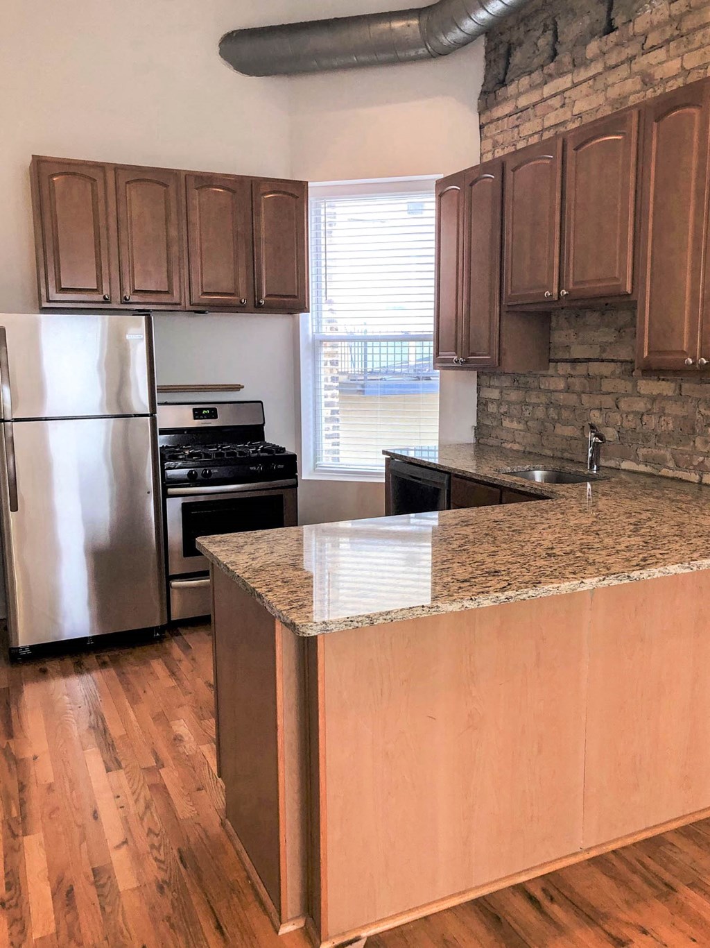 a kitchen with a granite counter top and a stainless steel refrigerator