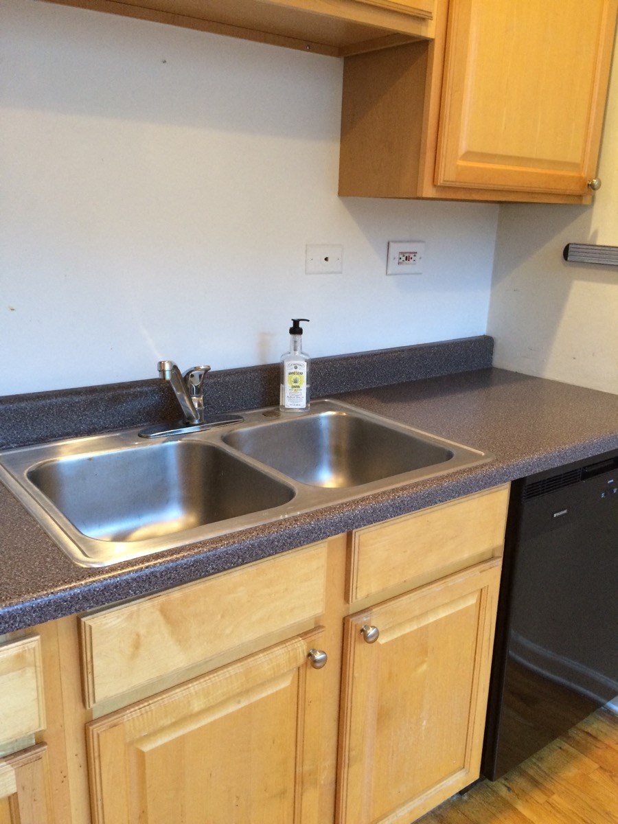 a kitchen with a sink and wooden cabinets