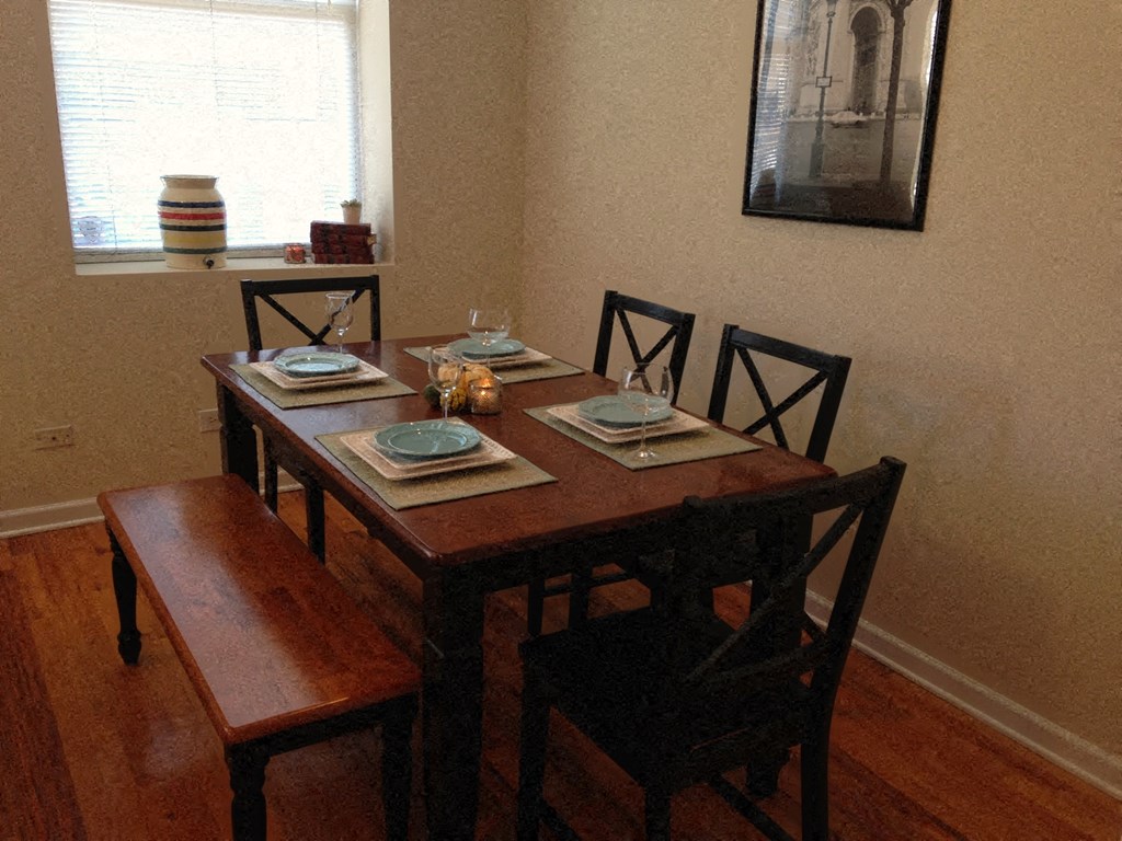 a dining room table with chairs and plates on it