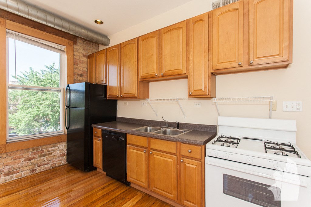 a kitchen with wood cabinets and a white stove and black refrigerator
