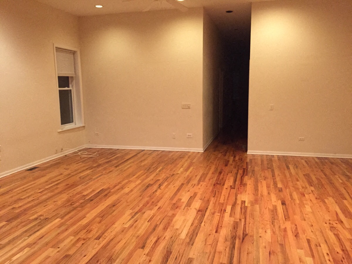 an empty room with wooden floors and a window