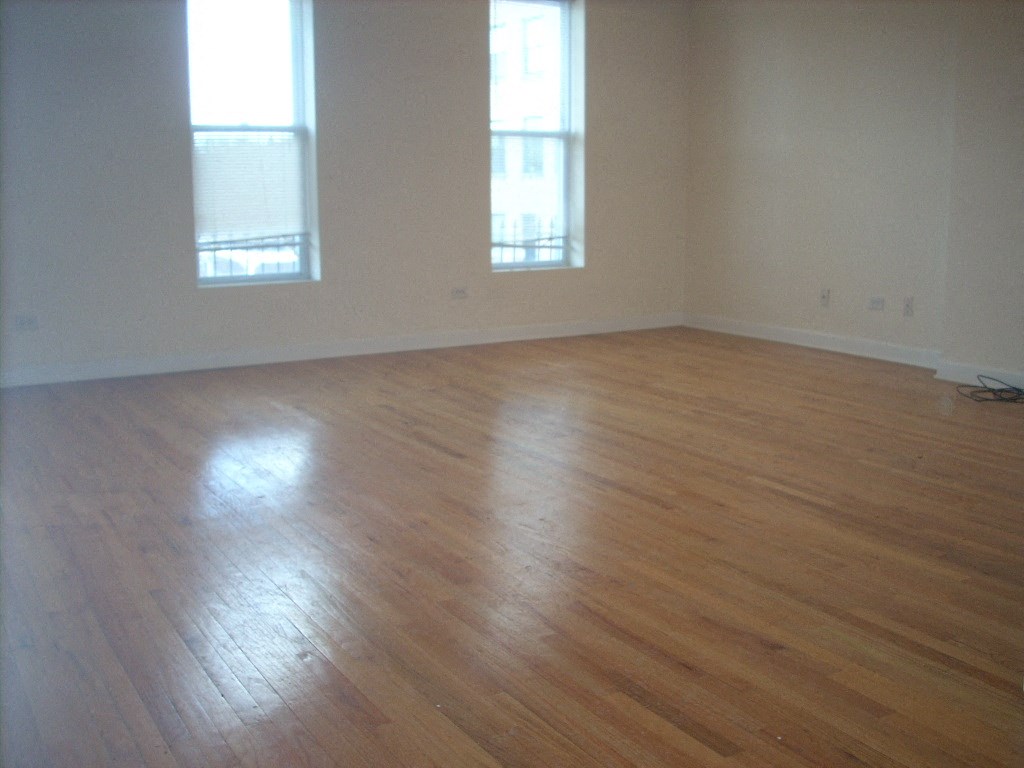 an empty living room with wooden floors