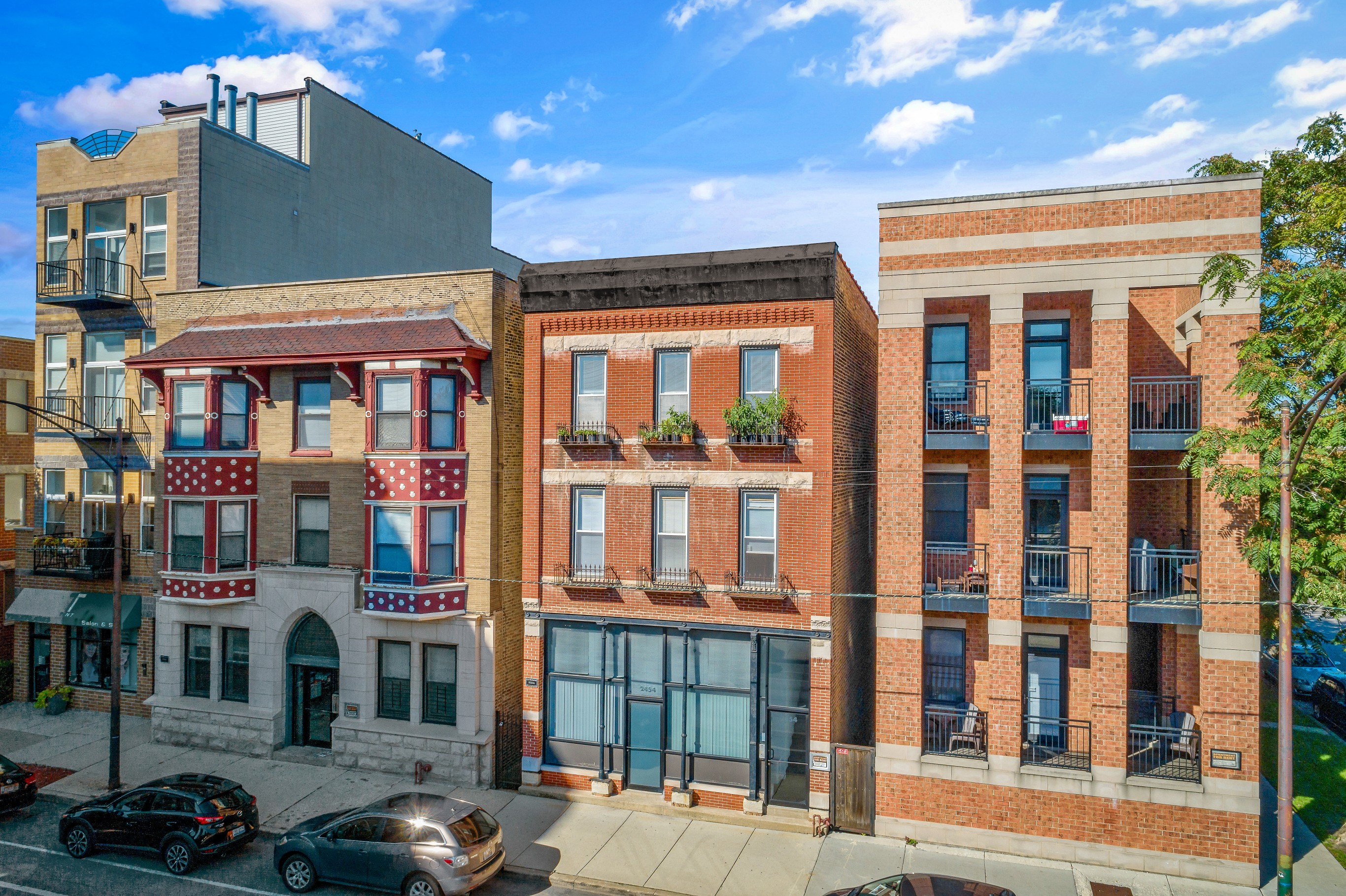 a row of buildings with cars parked in front of them