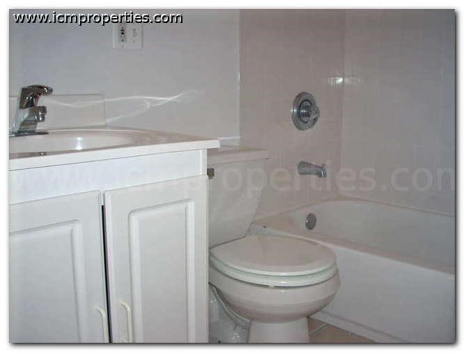 a white bathroom with a toilet and a sink