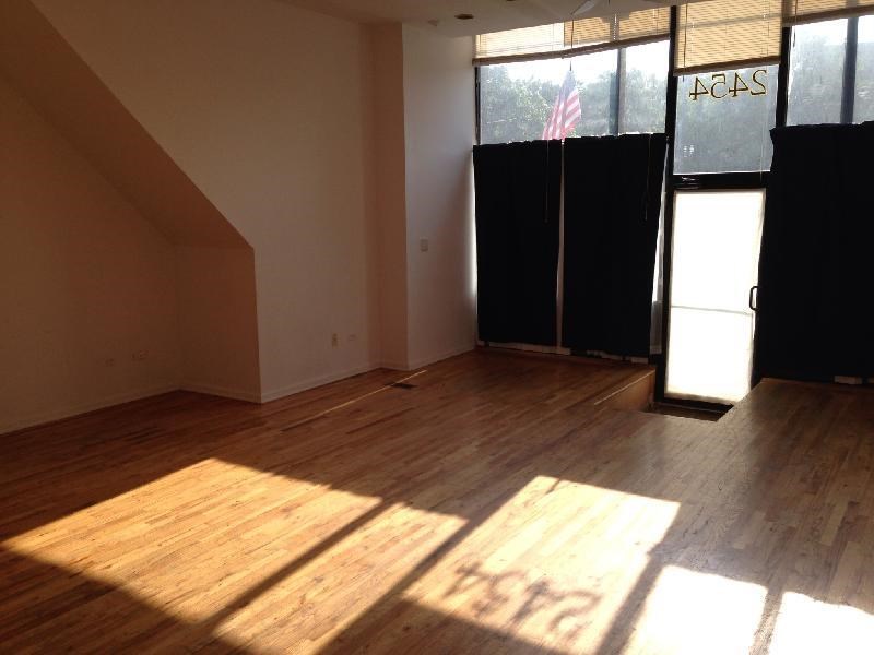 an empty room with a wood floor and windows