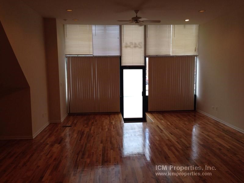 an empty living room with wooden floors and a door