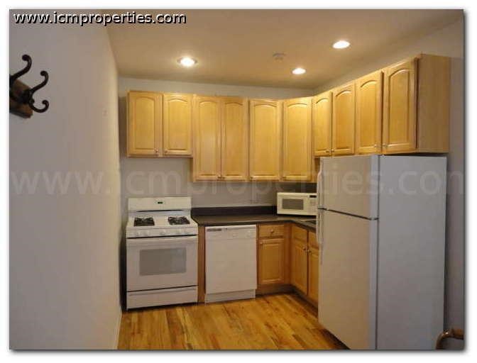a kitchen with white appliances and wooden cabinets