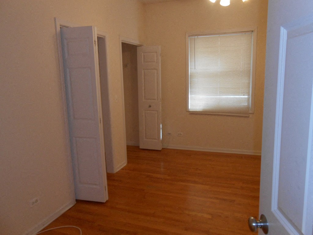 an empty room with two doors and a window