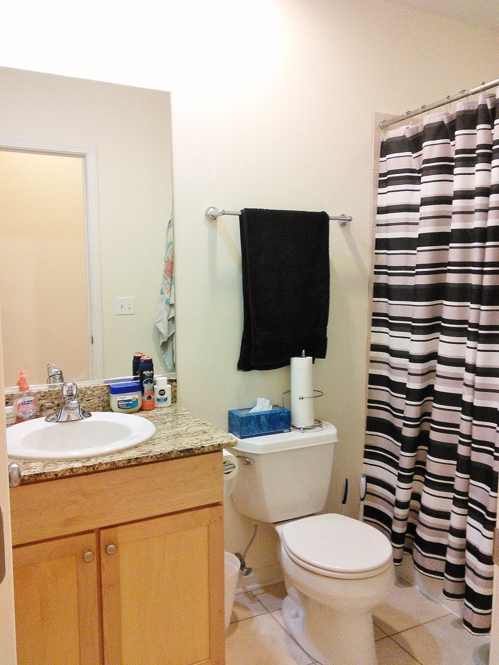 a bathroom with a toilet and a sink and a shower curtain