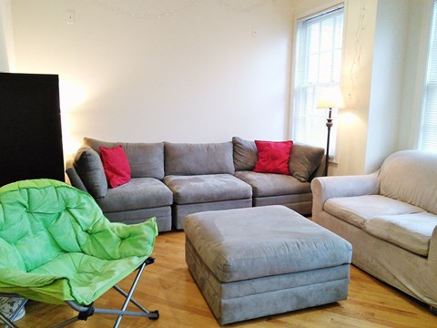 a living room with couches and a chair and a tv