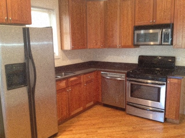 a kitchen with wooden cabinets and stainless steel appliances