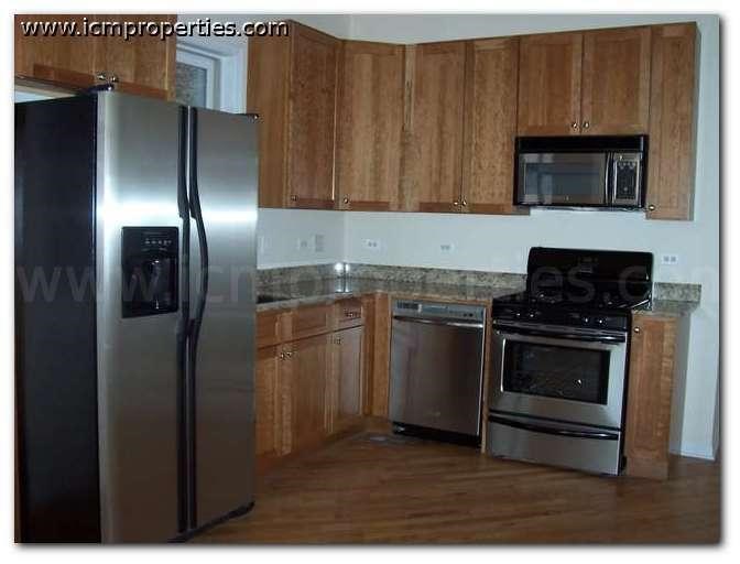 a kitchen with stainless steel appliances and wooden cabinets