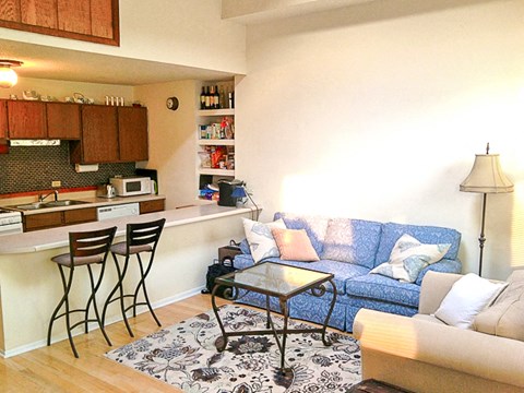 a living room and kitchen with a couch and a table