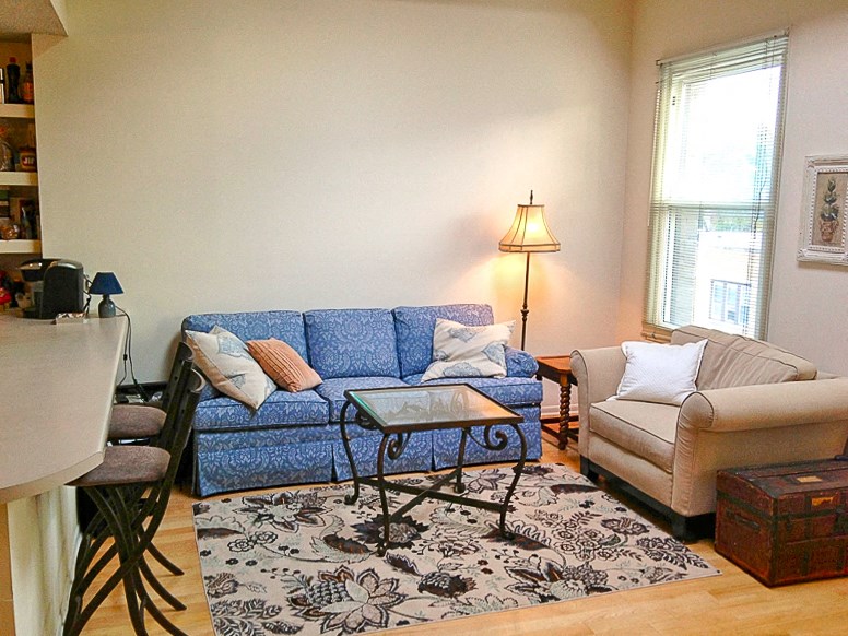 a living room with a blue couch and a chair