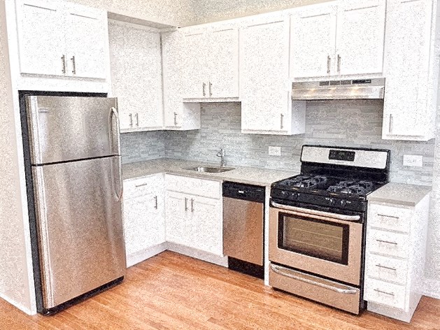 a kitchen with white cabinets and a stainless steel refrigerator