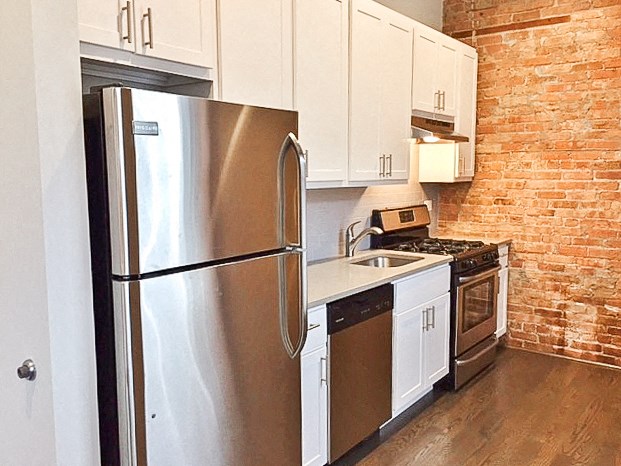 a kitchen with a stainless steel refrigerator and white cabinets