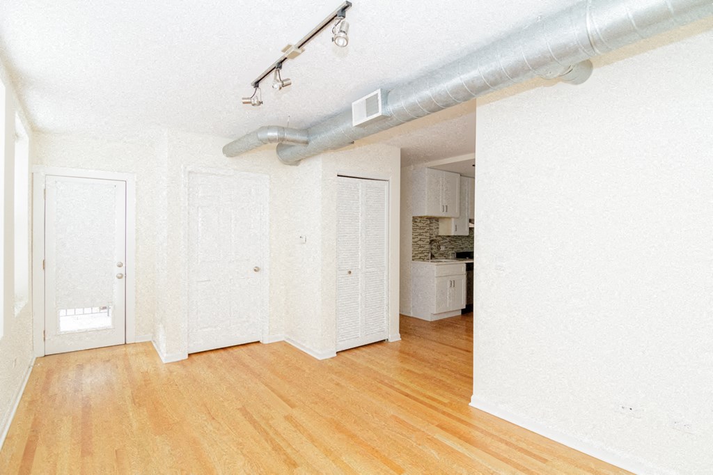 an empty living room with white walls and wood floors