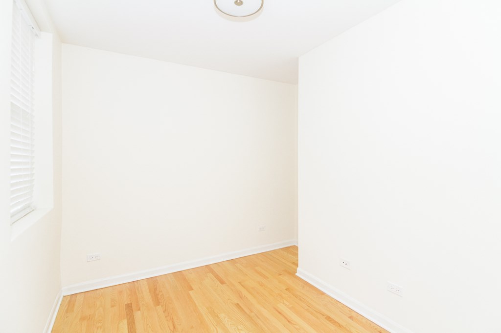 an empty room with wood floors and white walls